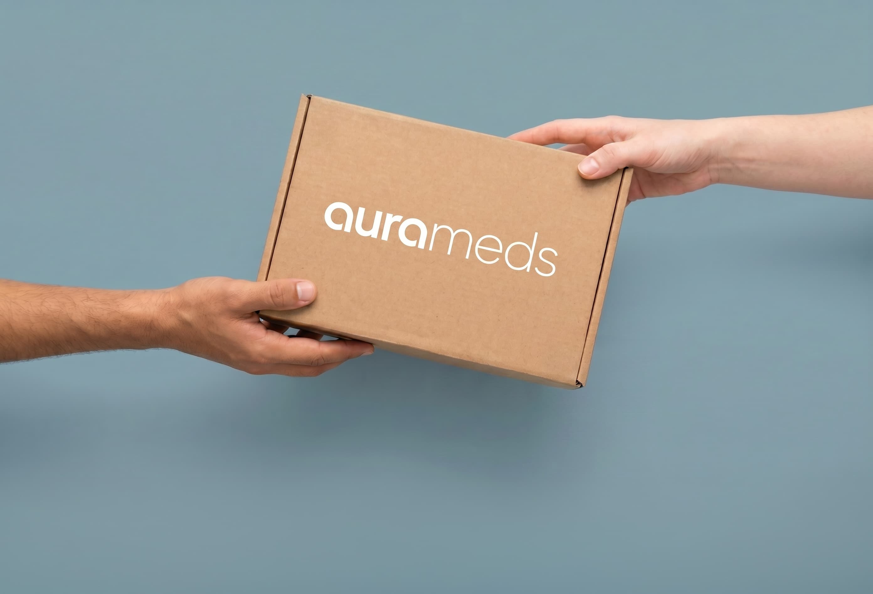 Aura Meds delivery box passed between two hands